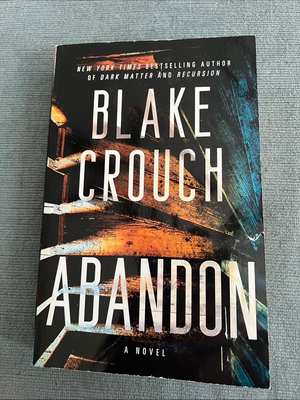 Abandon by Blake Crouch — Paperback Novel in Black, Orange, Blue Cover
